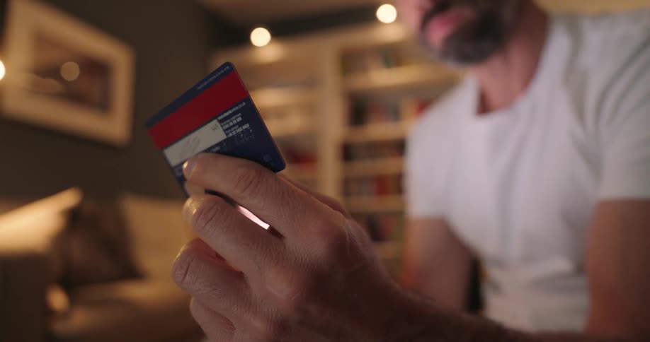 A man looks at a credit card