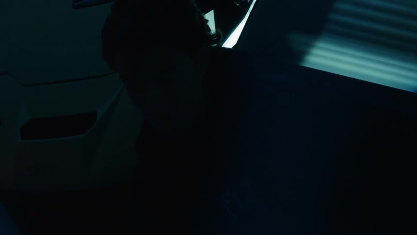Silhouette of a person next to a lamborghini with headlights on