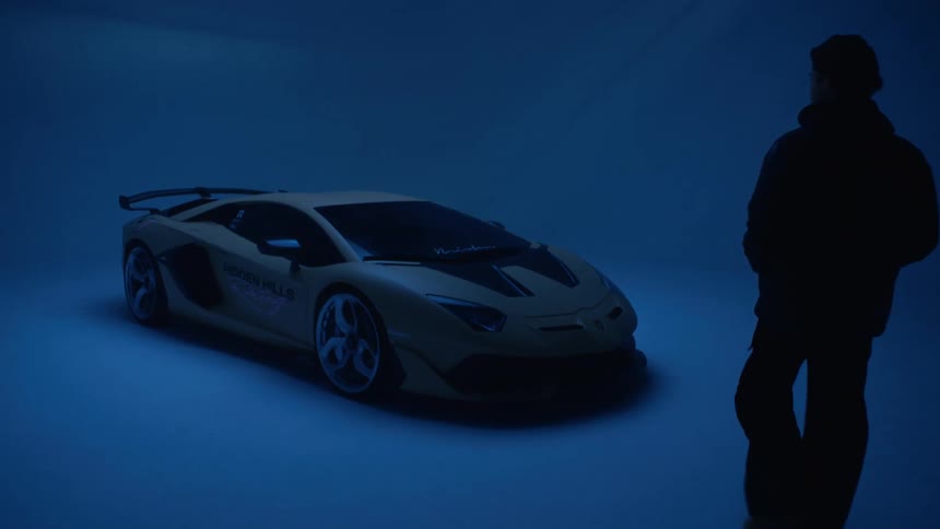 A man walks over to the sports car in the showroom