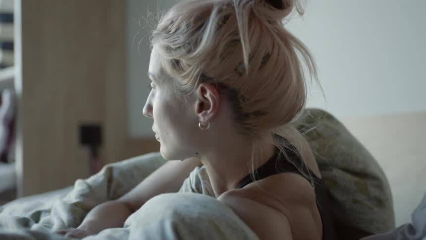 A woman rolls around and gets up in bed