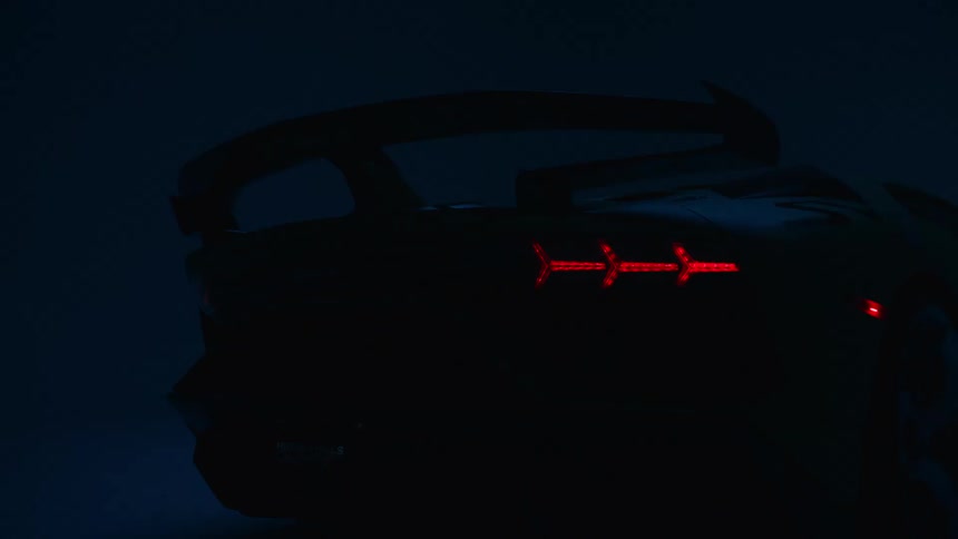 Car taillights lit in red form arrows visible in the dark