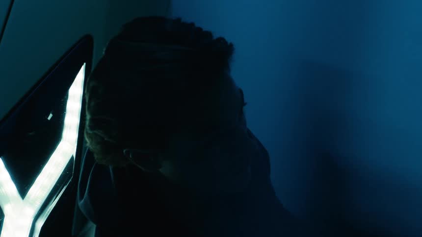 Blue light flashes near a silhouette of a person