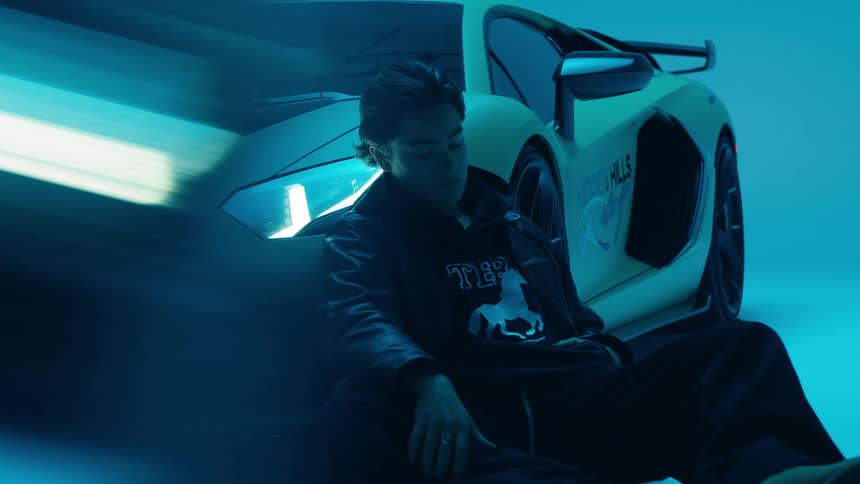 Lights flash on the car with a man sitting on its side
