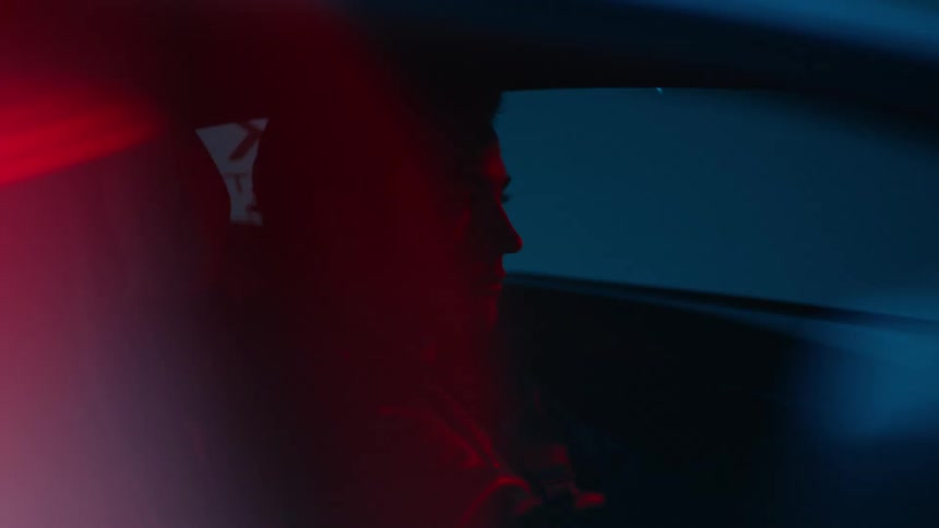 Male driver silhouetted against the side window is occasionally lit by red lighting