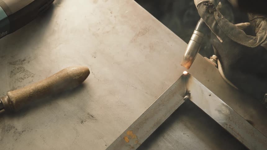 A welding tool used to weld a tub of iron pipe giving off several blue sparks