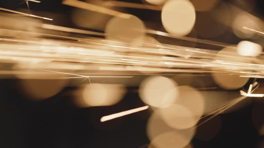 Closeup of sparks flying as a piece of metal is being polished