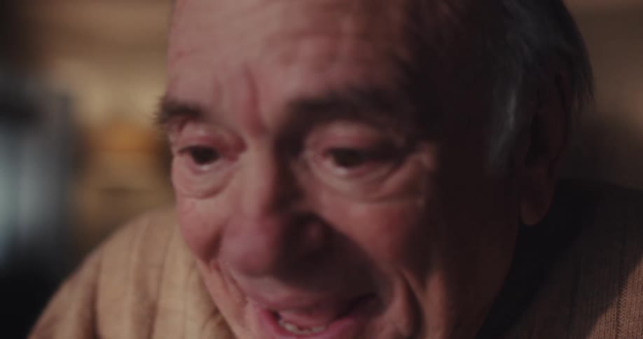 An elderly man screams with joy during a video call on a tablet