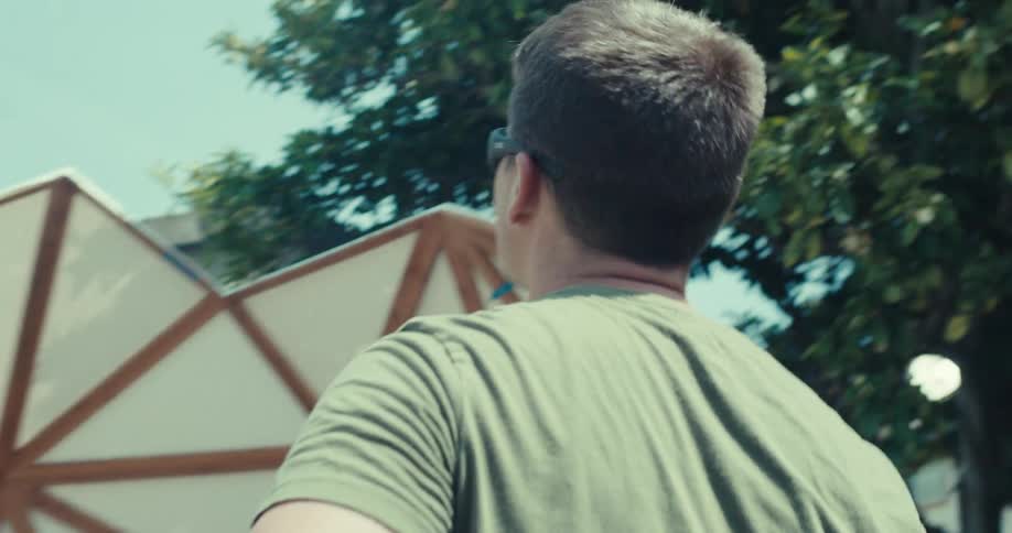 A man gazes at a geodesic dome as the camera moves in on his face