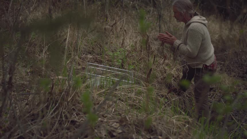 A man sniffs a plant he picked