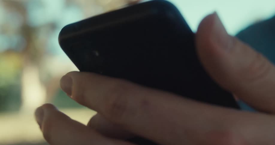 A man is smiling while using his cell phone