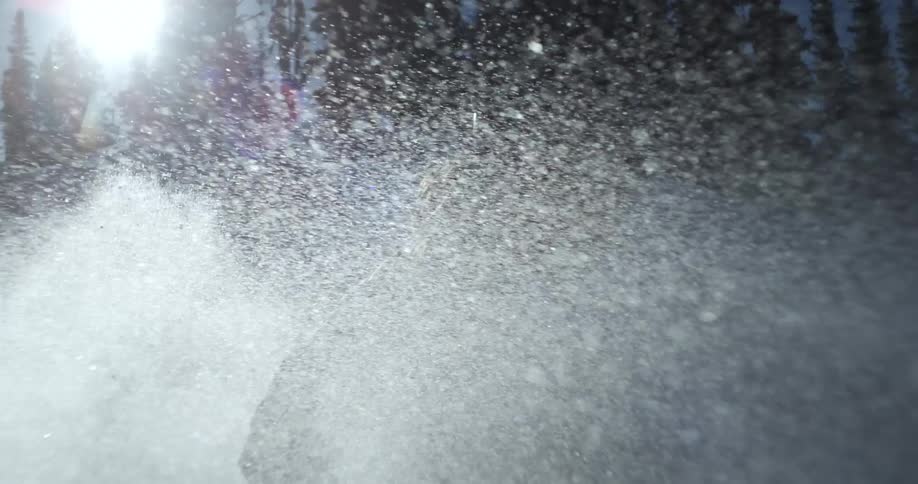Snow flies in the skiers face