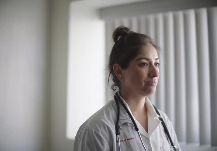 Nurse in white coat in a clinical room