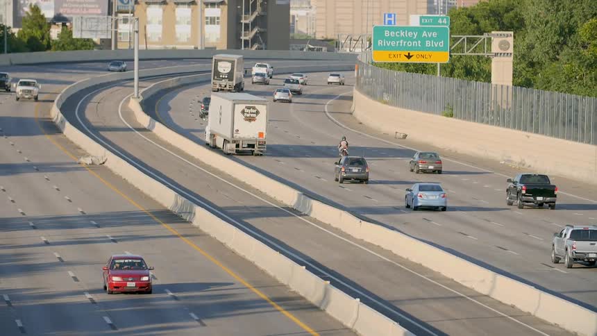 Vehicles move in slow motion on a city highway