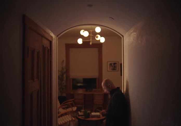 Man using his cell phone in the hallway of a room