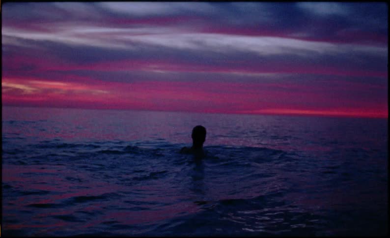 A man gets into cold water at the beach
