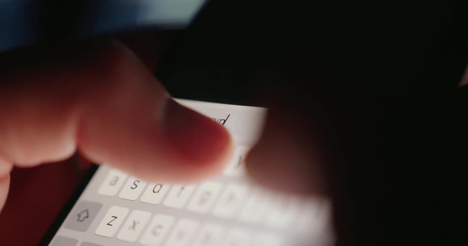 A closeup shot shows fingers typing the word crypto into a search bar on a smartphone screen