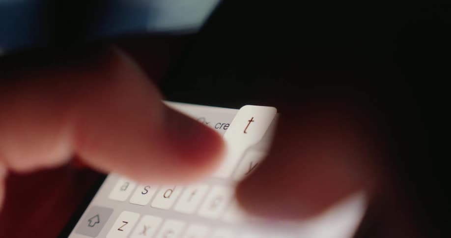 A closeup shows fingers typing the word credit on a smartphone keyboard