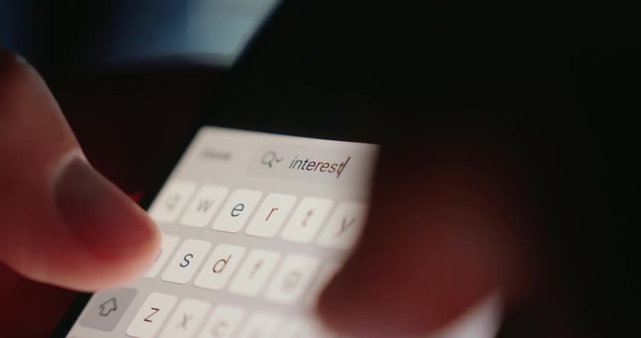 A keyboard on a phone is lit up as a person types on it