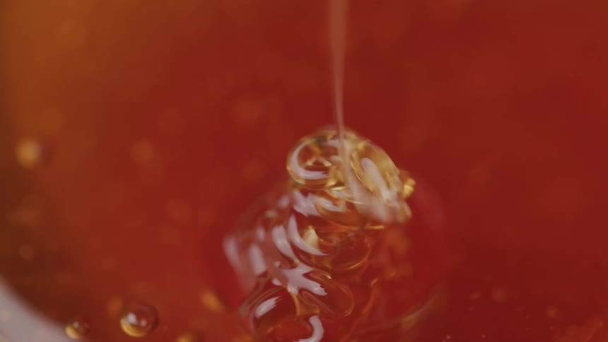 Honey slowly melts into a puddle as its being poured