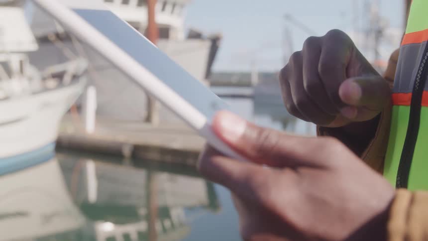 A man on a dock using a tablet