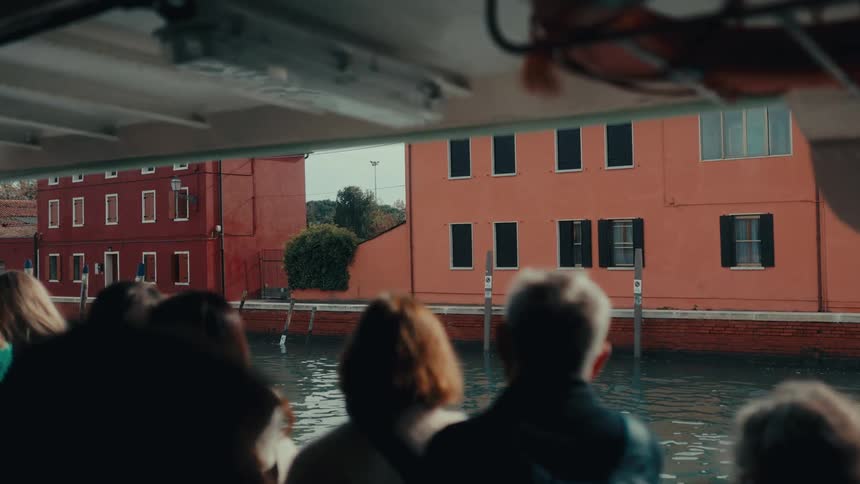 A ferry full of tourists ride in the canal in the city