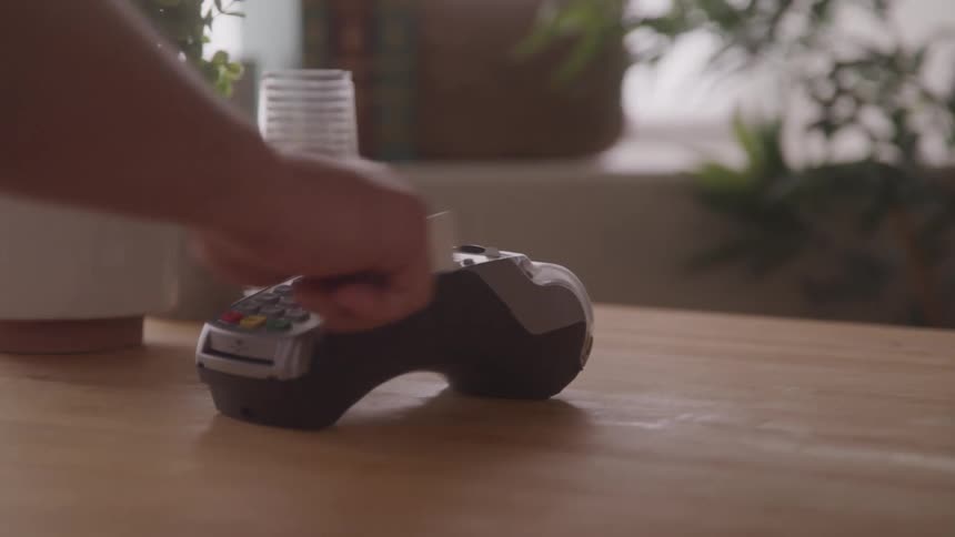 A person swiping a credit card on a card reader