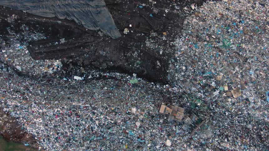 Birds eye view of a bulldozer plowing through a landfill