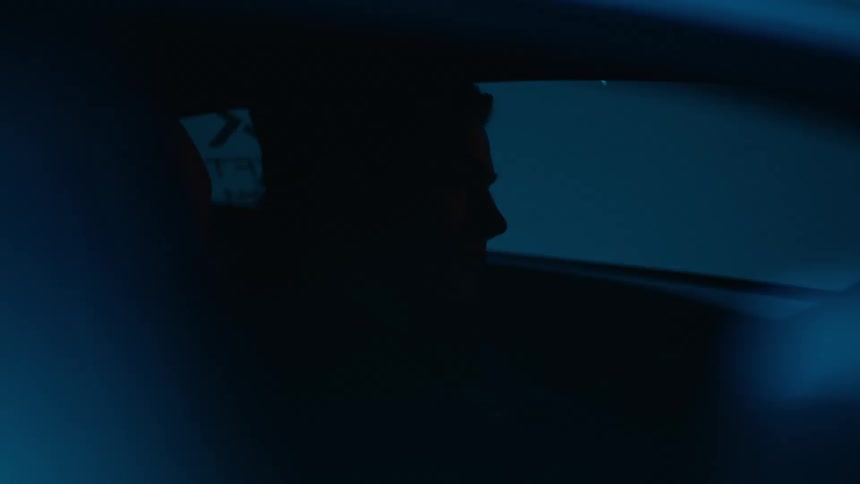 Red lights are flashing all over the man in the car