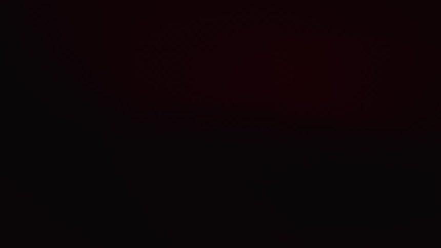 Red lights flash on the man sitting in the dark
