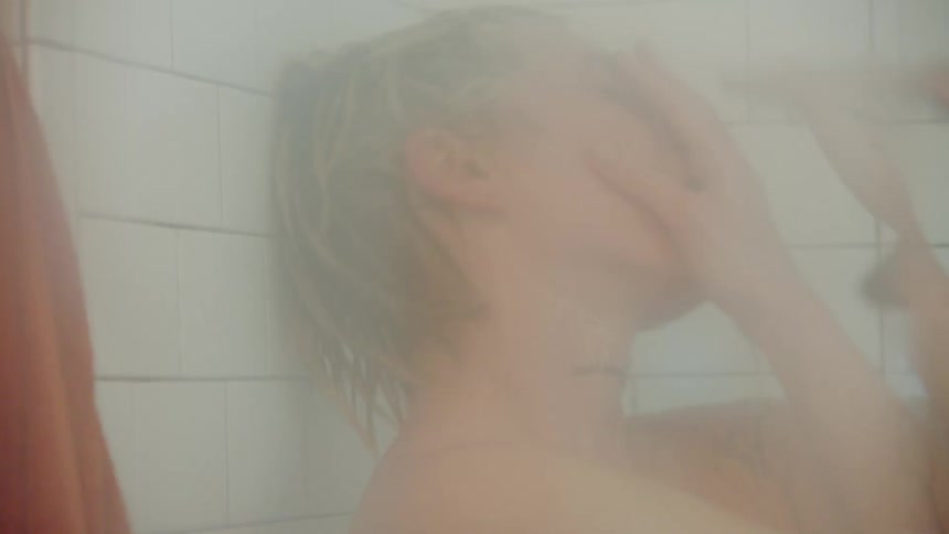 Person dances slightly while taking a shower in a tiled bathroom