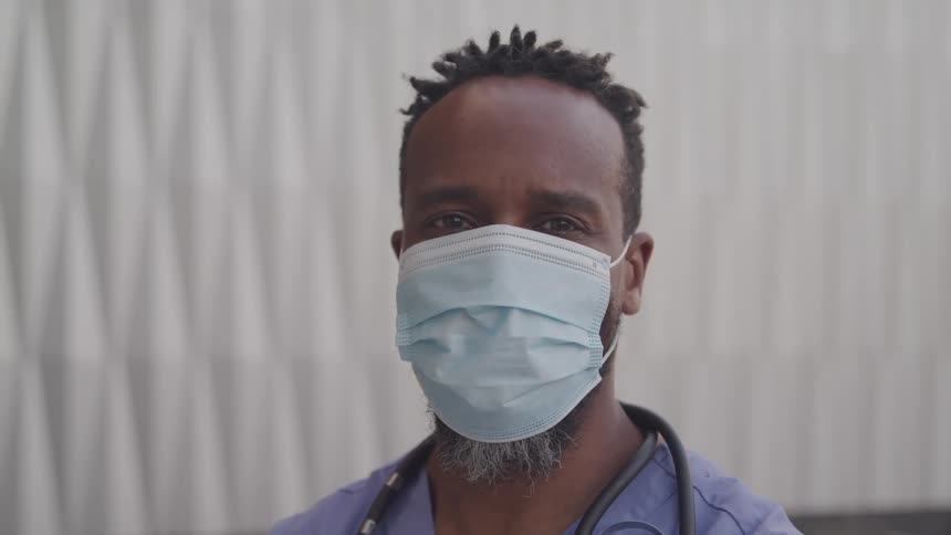 The doctor is outside using a face mask