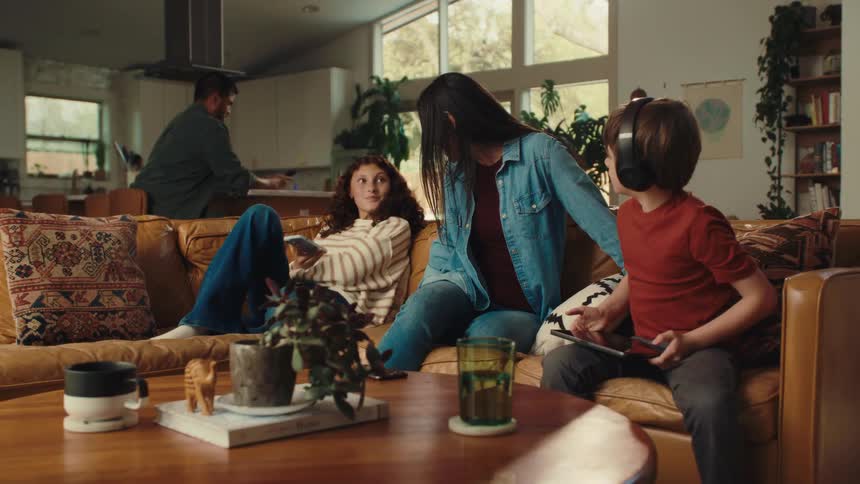 A family get off the couch and walk to the kitchen
