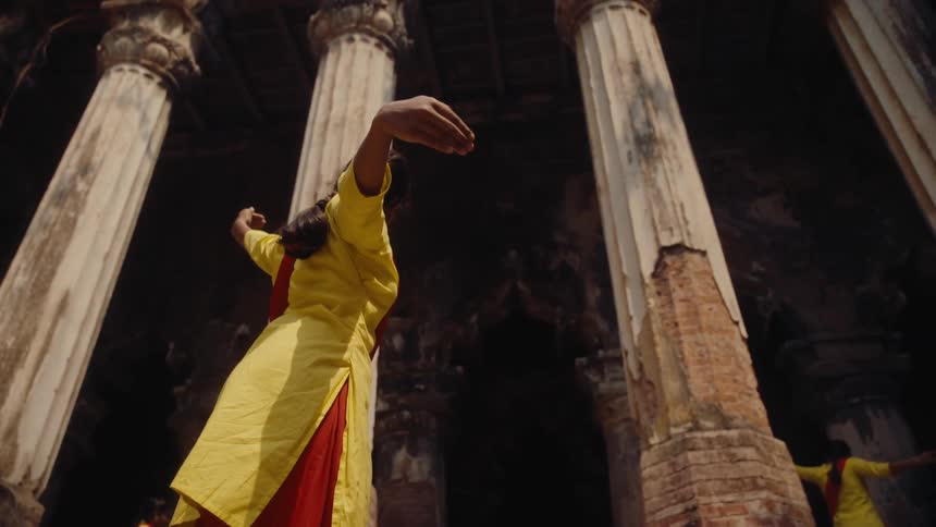 Women are dancing by the tall pillars