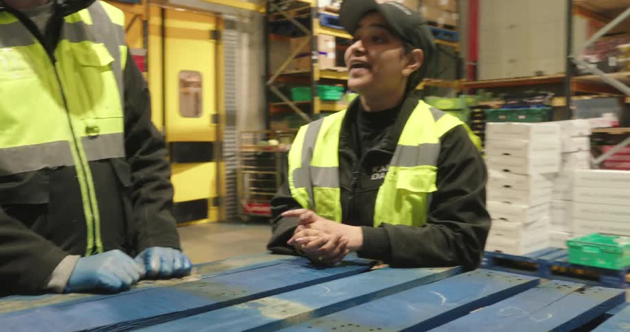 Warehouse workers chat while taking a short break in the warehouse