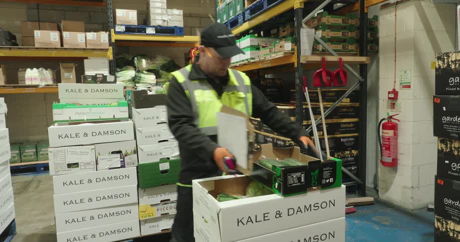 The worker is taking inventory and writing on a clipboard