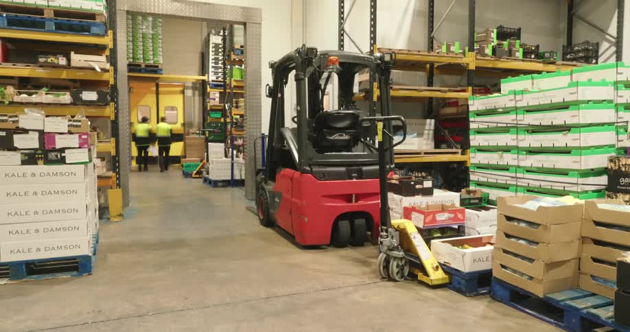 Workers walk through the warehouse and grab boxes
