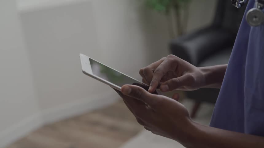 The doctor is using a tablet inside