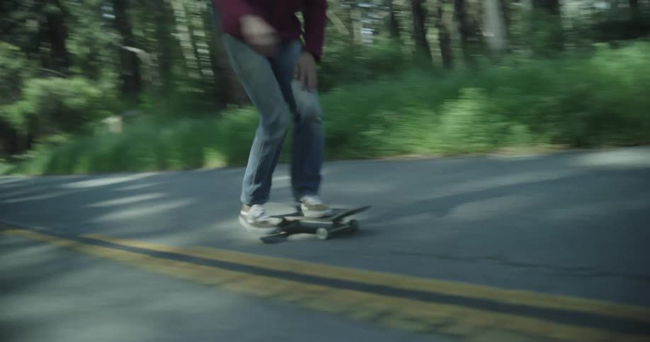 A man rides his skateboard on the road