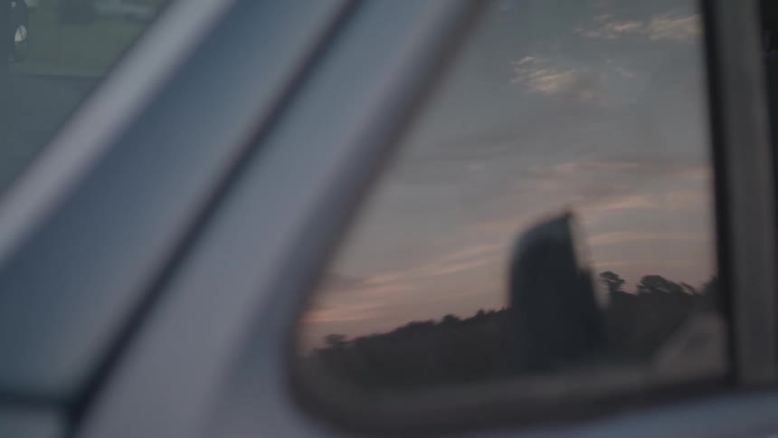 The sky is shown through the side window of a moving truck