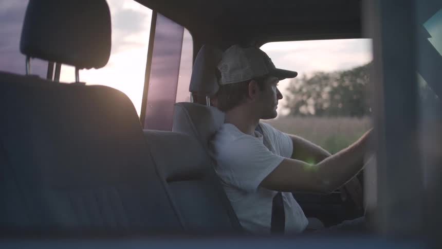 Man in cap sitting inside a vehicle