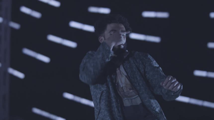 Curly haired man in a dancing performance