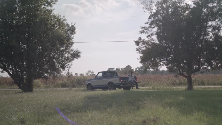 A guy sits on the bed of his truck