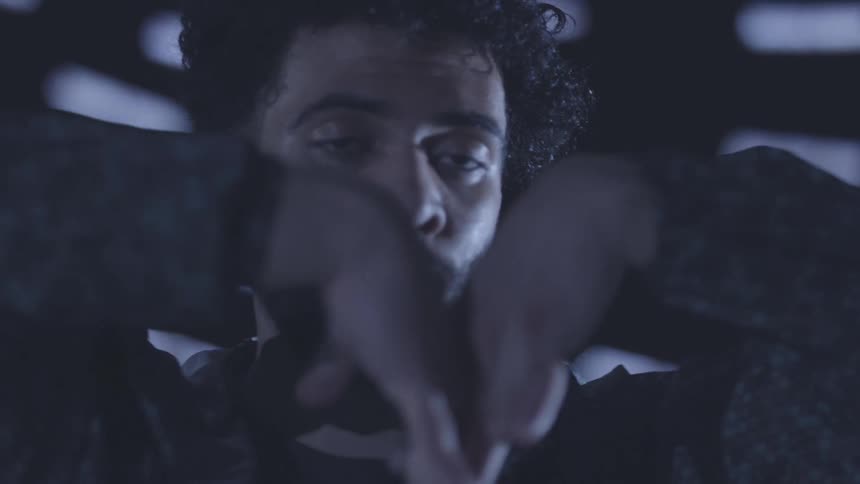 A man waves his hands around while dancing