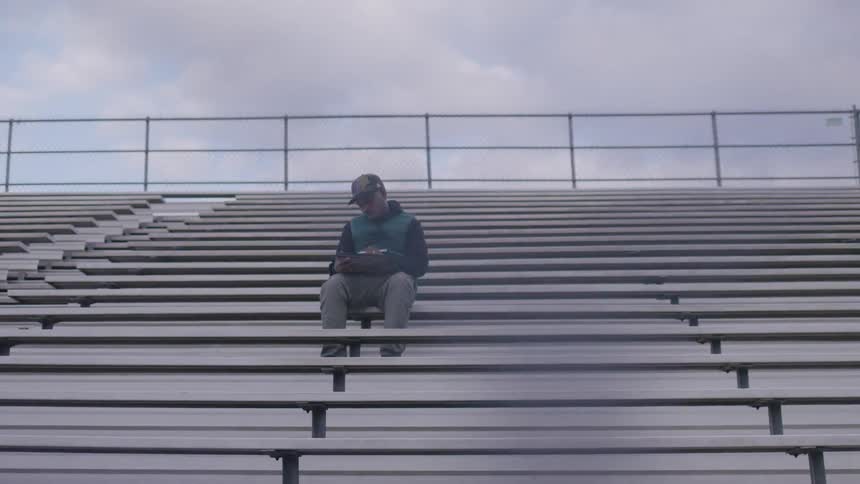 A man sits on the bleachers