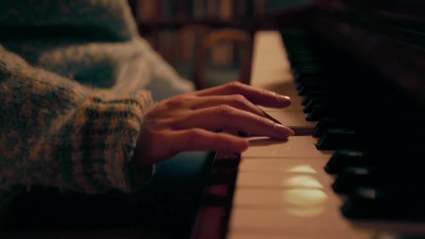 Close up of a womans hand playing the piano