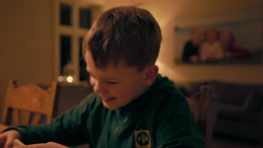 Boy sitting at table playing with dominoes