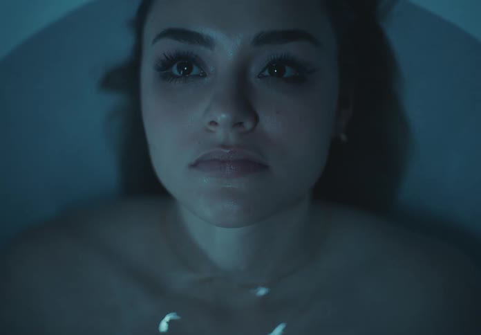 A woman goes underwater in the bathtub