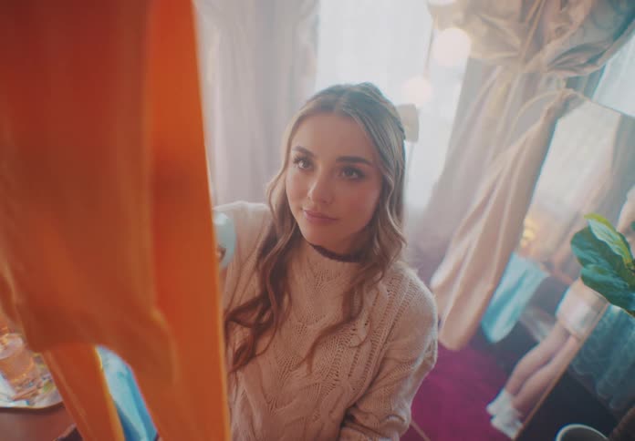 A woman is steaming a piece of clothing