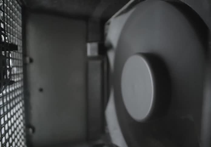 A tight shot of a large industrial fan inside a metal enclosure