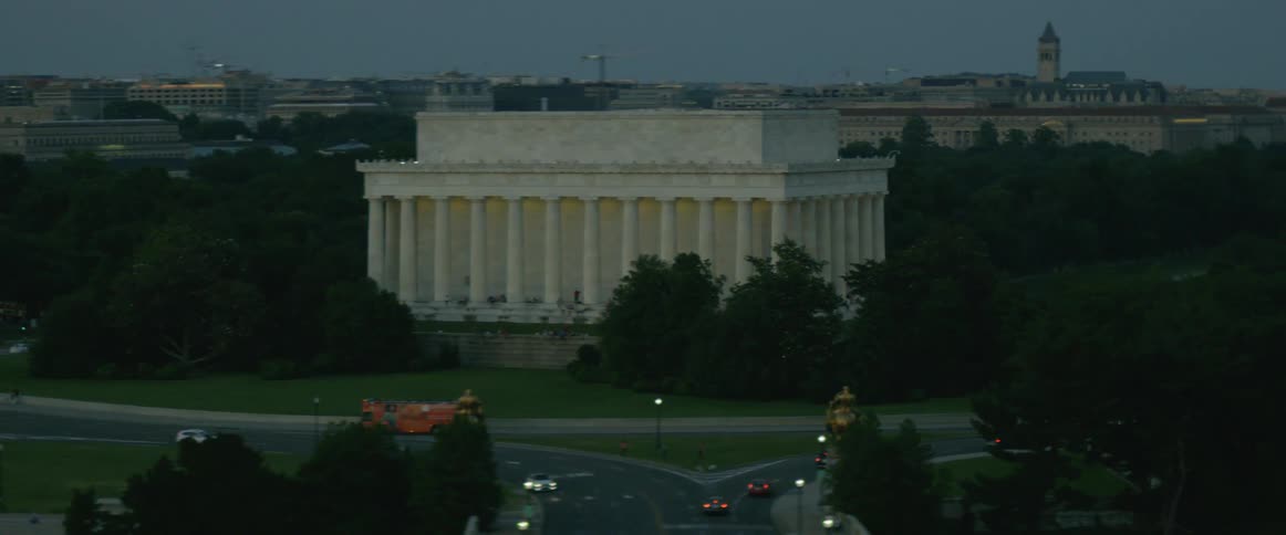 A tall building is surrounded by pillars in the distance